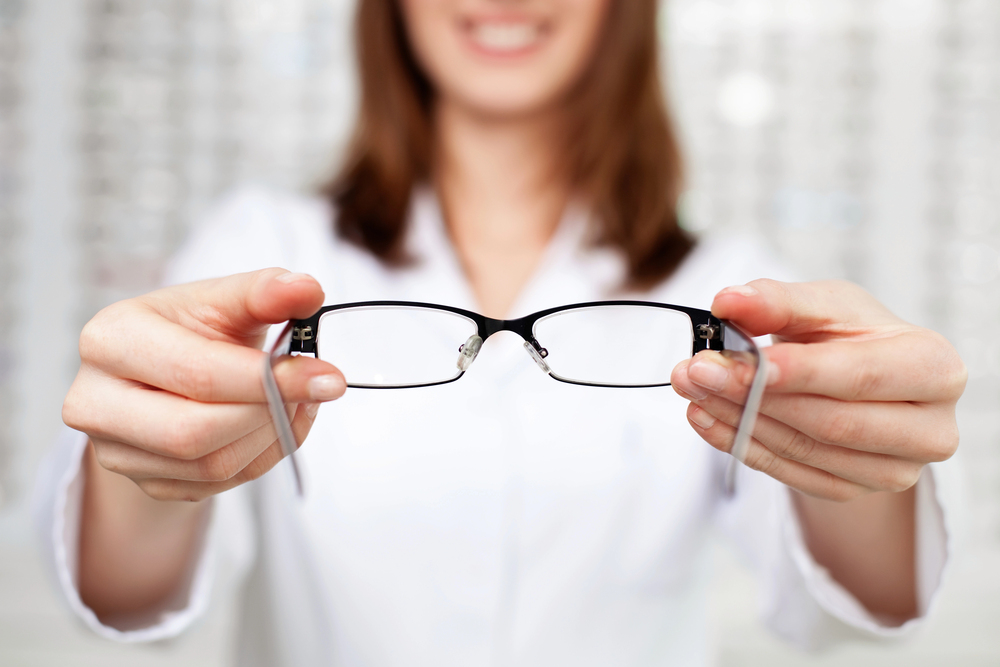 Optician presenting eyeglass frames to patient in Broken Arrow