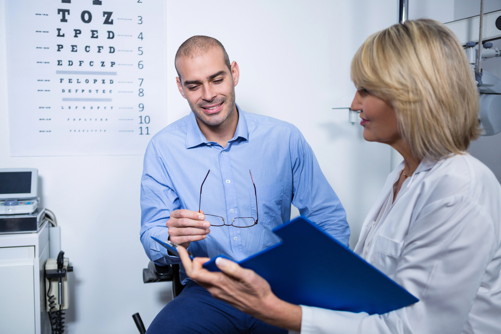 Optometrist consulting with patient about vision insurance and glasses options