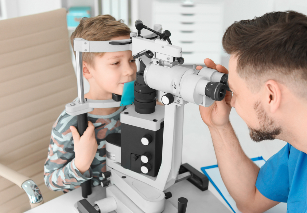 Young boy receiving pediatric eye exam with slit lamp at Tulsa children's eye doctor