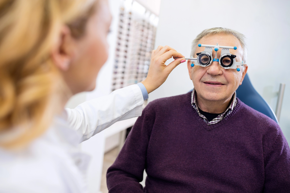Senior man getting comprehensive eye exam with trial frame in Tulsa
