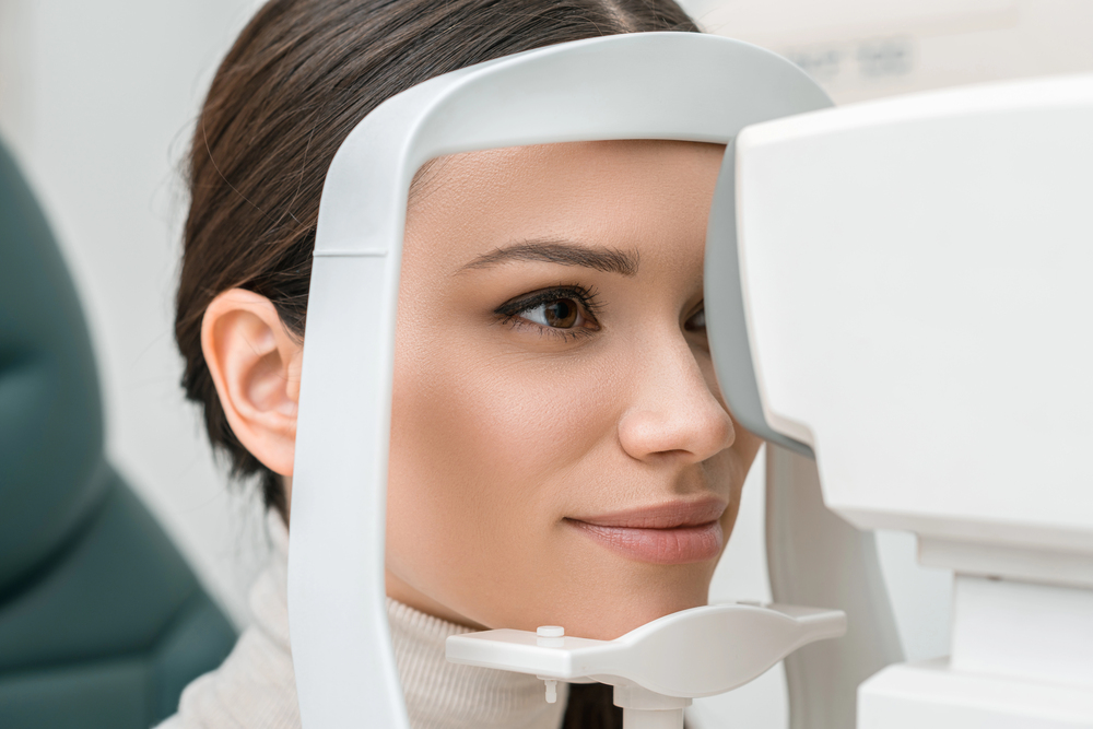 Patient receiving comprehensive eye exam with autorefractor at Tulsa optometry clinic